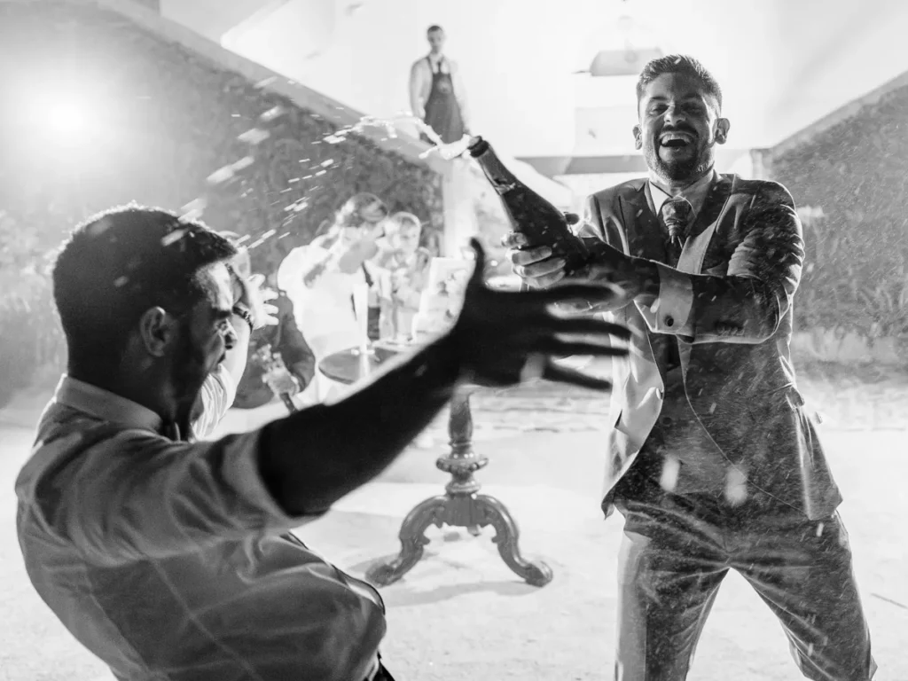 O noivo Diogo a dar um banho de champanhe super animado aos convidados durante o corte do bolo de casamento em Alenquer.