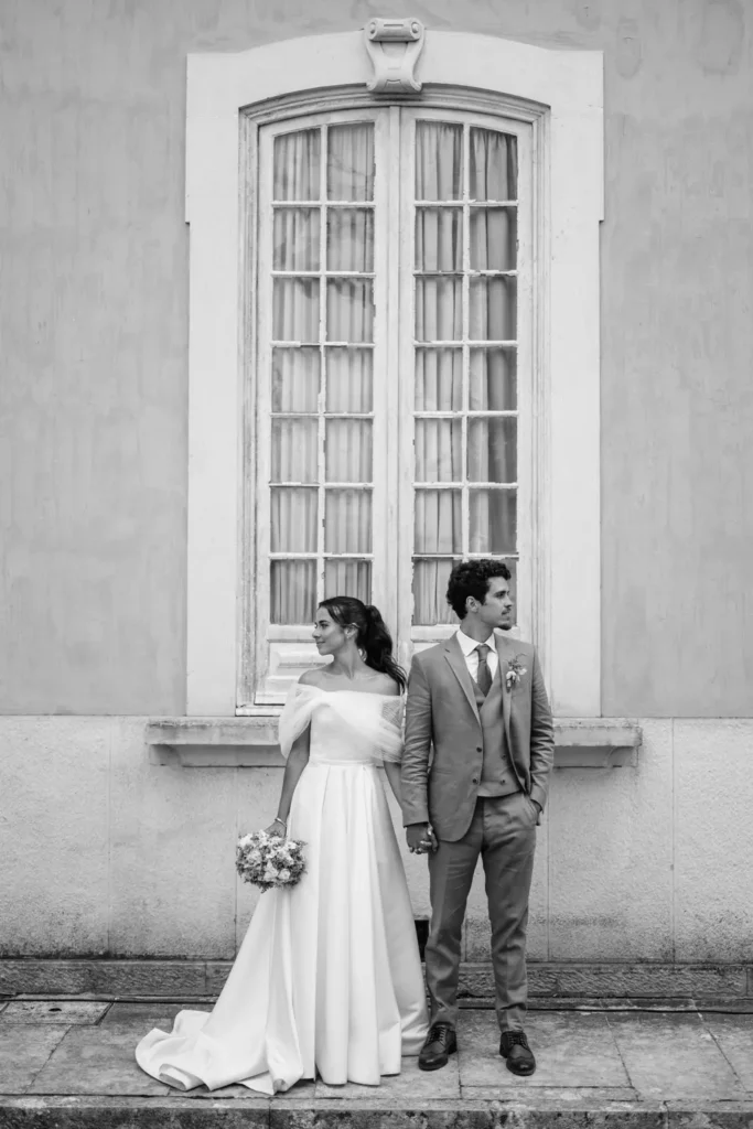 Couple in their wedding day in Portugal in front of a window on their destination wedding in Portugal