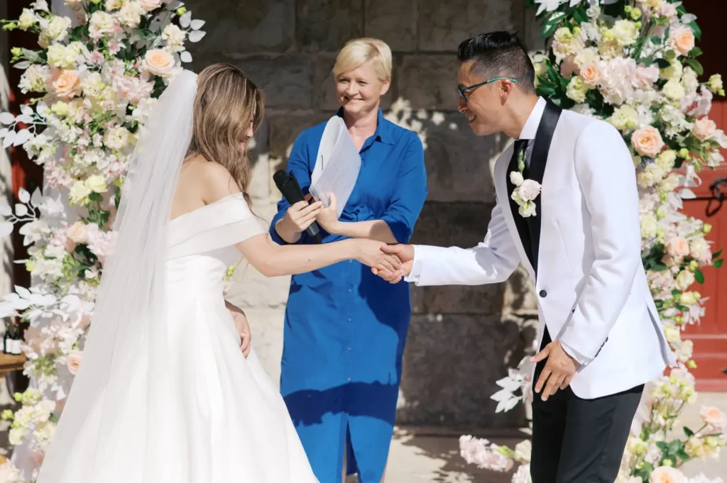 Noivos divertidos a jogar pedra, papel ou tesoura durante a cerimónia de casamento no Forte da Cruz, Cascais.