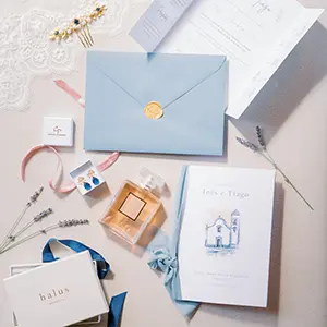 Detalhes de casamento em estilo fine art incluindo convite azul com lacre dourado, perfume e acessórios da noiva, fotografado por Boris the Cat.
