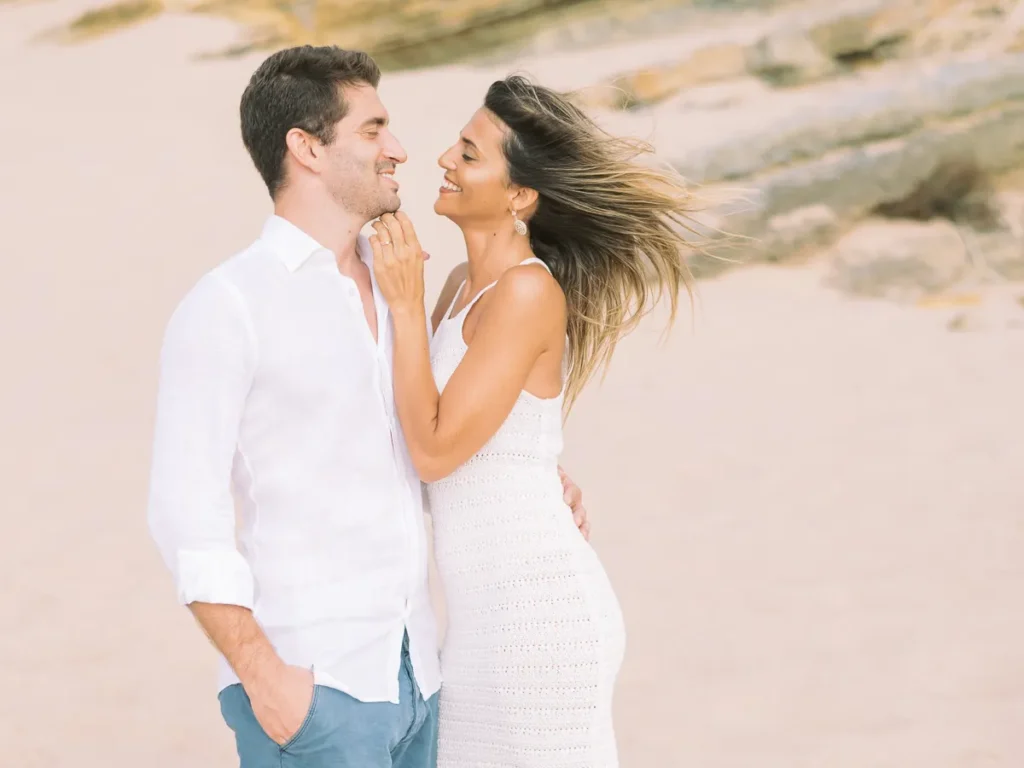Casal a sorrir durante sessão fotográfica pre-wedding nas dunas de Cascais.