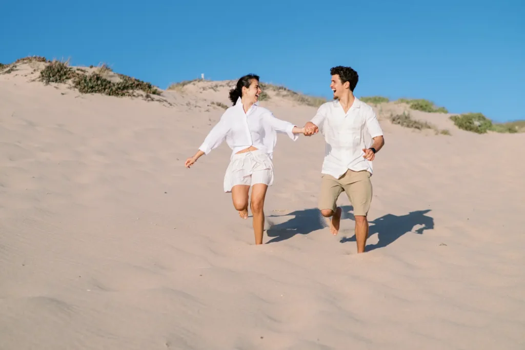 Fotografia documental de noivos a divertirem-se nas dunas da Praia da Crismina em Cascais.