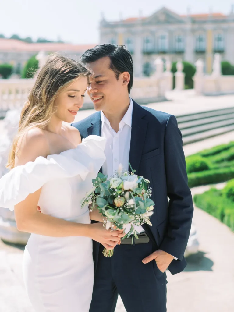 Retrato fine art de noivos nos jardins do Palácio Nacional de Queluz sob o sol de verão.