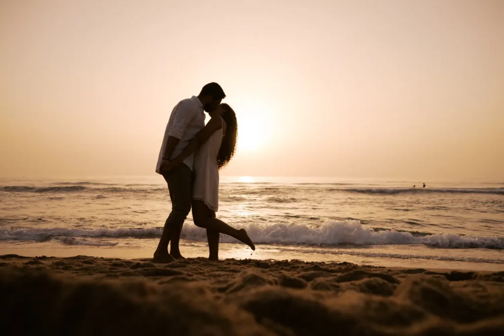 Casal de noivos a namorar na Praia do Porto Novo no Vimeiro, Torres Vedras, com luz de golden hour.