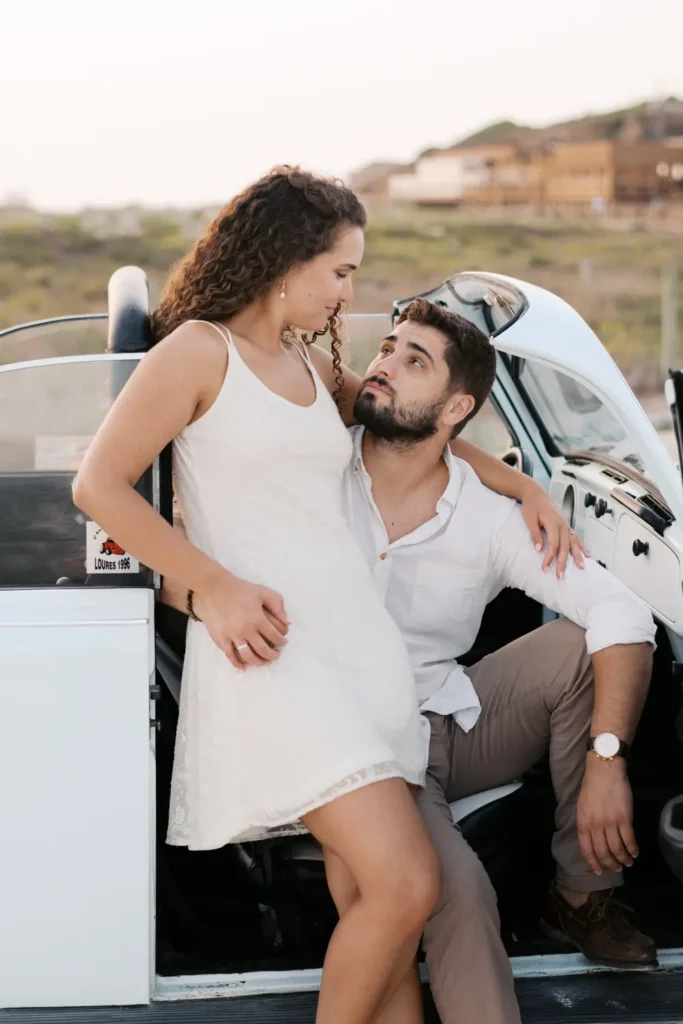 Sessão pre-wedding na praia com carro clássico Volkswagen Carocha antigo.