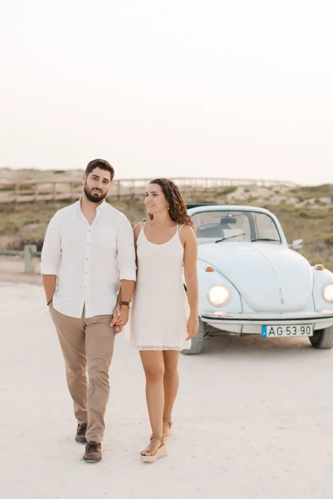 Sessão pre-wedding na praia com carro clássico Volkswagen Carocha antigo.
