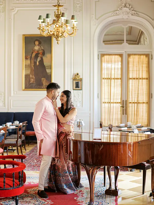Retrato editorial de noivos indianos com trajes tradicionais elegantes durante uma sessão fotográfica antes da festa de Sangeet em Portugal, no Pestana Palace em Lisboa