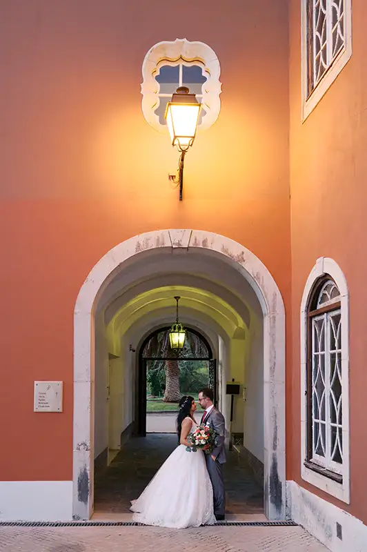 casal de noivos no dia do seu casamento em sessão fotográfica descontraida no resort penha longa em sintra - cascais debaixo de um candeiro