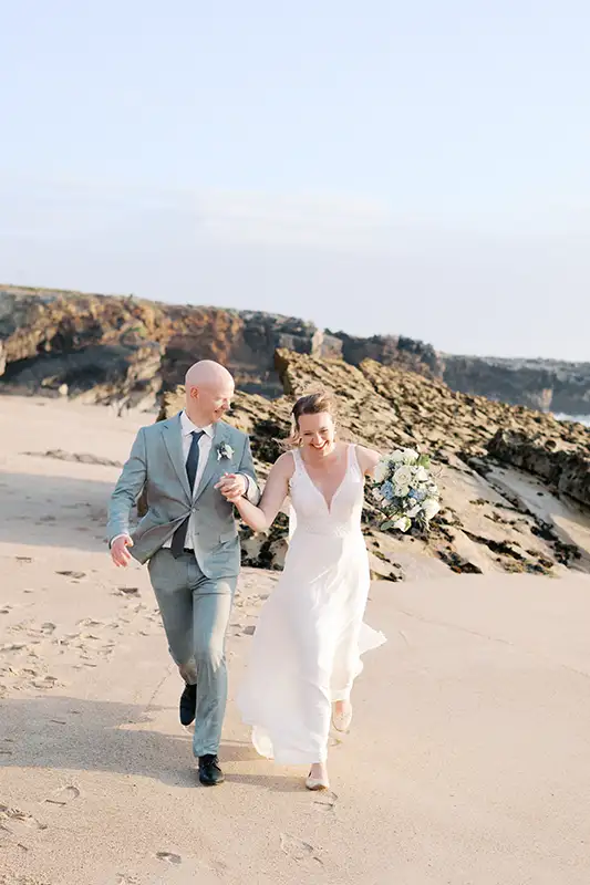 casal a correr na praia ao final da tardde no dia do seu casamento em cascais no Arriba by the Sea